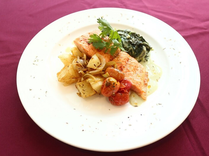 Baked salmon with spinach, tomatoes, and herb potatoes, a high-protein meal for pregnancy.