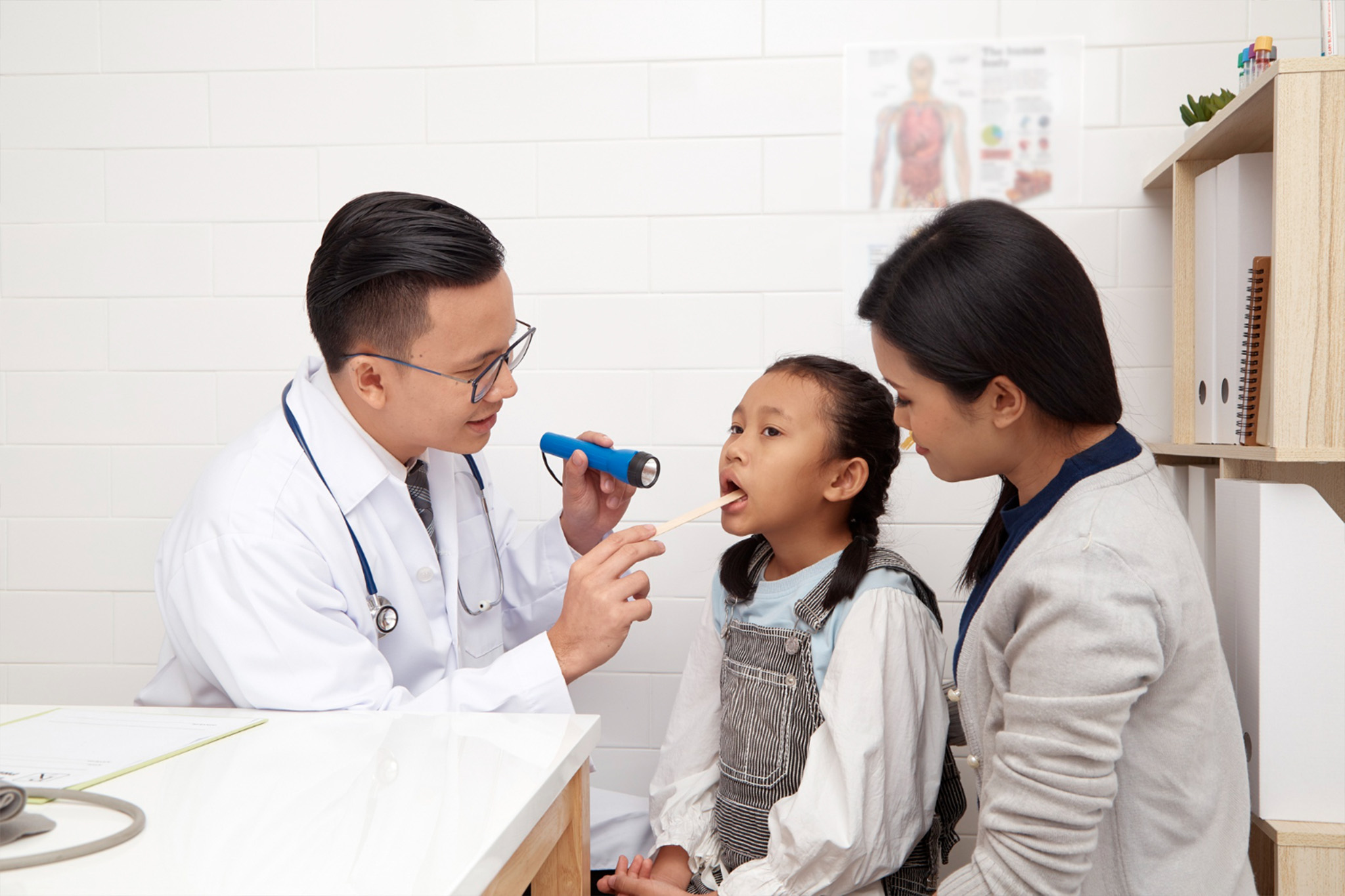 Pediatrician examining a child in clinic during routine health visit and development check