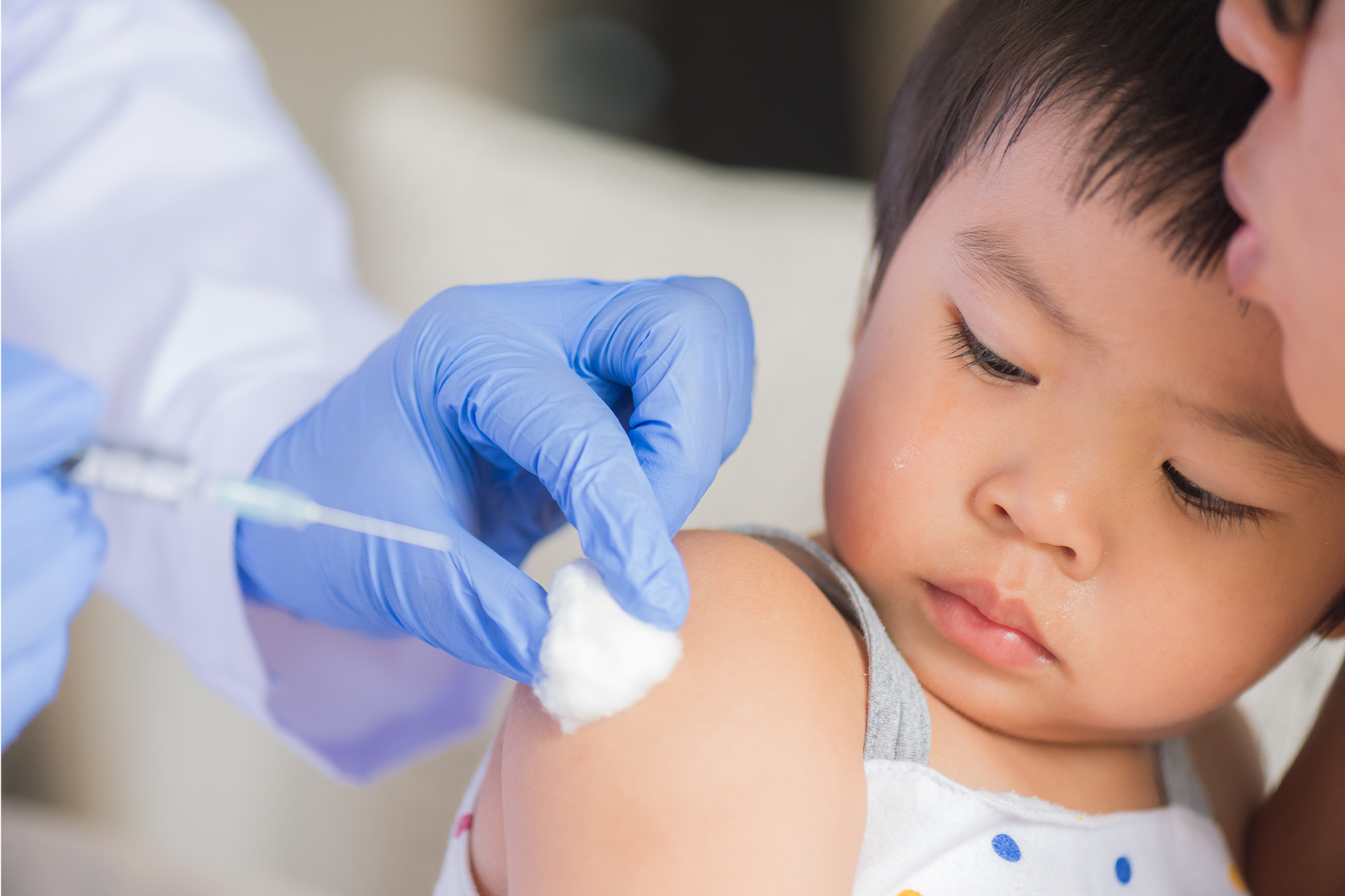 Nurse administering routine childhood vaccine to child during immunization session