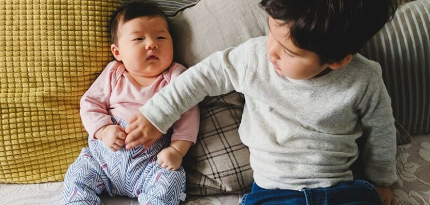 Kanak-kanak menenangkan bayi yang kelihatan tidak selesa, antara tanda bayi kembung perut