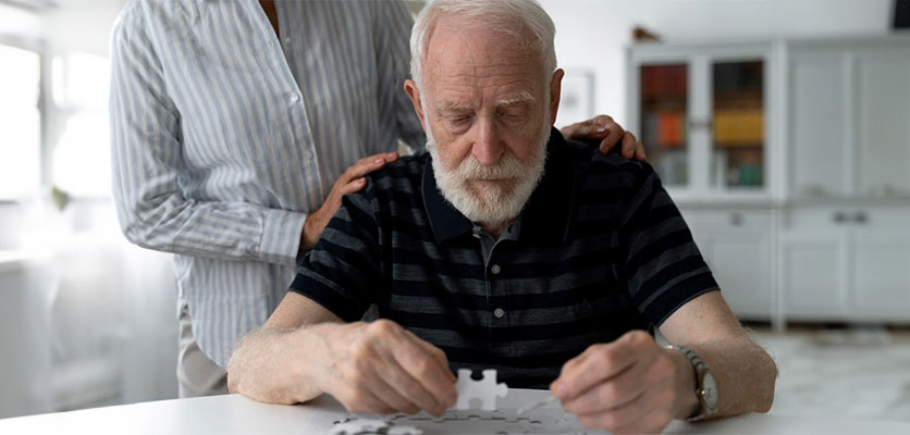 An elderly man is working on a puzzle activity for mental exercise and memory support