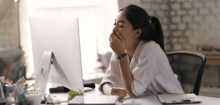 Woman yawning at her desk from lack of sleep, linked to higher blood sugar and insulin resistance in diabetes